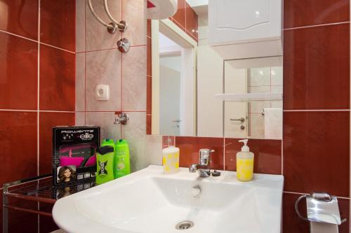 y baño con lavabo blanco y espejo. en Apartment with private swimming pool, en Podstrana