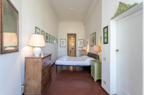 um quarto com uma cama e um candeeiro numa cómoda em Canottieri em Florença