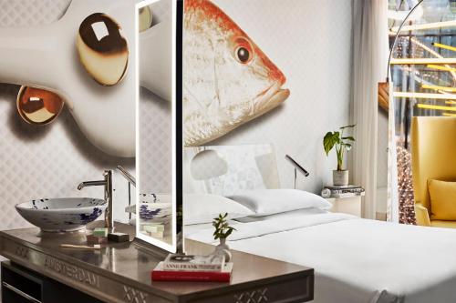 a bedroom with a bed with a mirror and a sink at Andaz Amsterdam, Prinsengracht, By Hyatt in Amsterdam