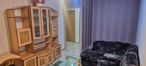 a living room with a cabinet and a chair at Cute Flat in Kėdainiai