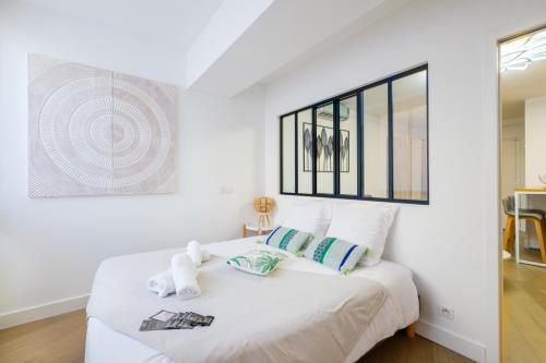 a bedroom with a white bed with a teddy bear on it at Appartement promenade des anglais in Nice