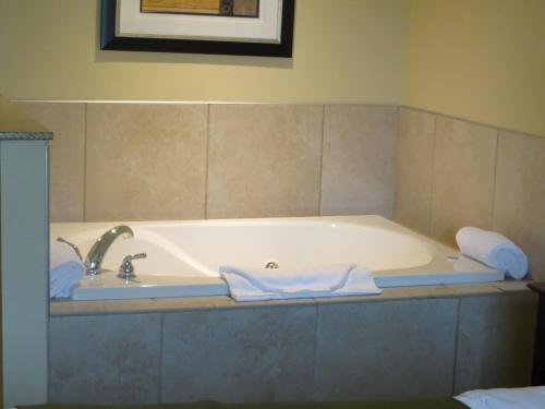 a bath tub with a sink and towels on it at Cobblestone Inn & Suites - Brillion in Brillion