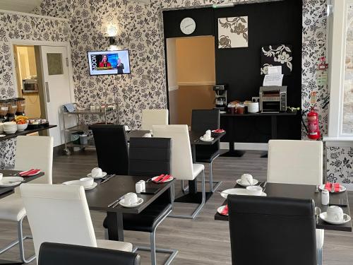 a restaurant with white chairs and tables with shoes on them at The Claymore Guest House in Pitlochry