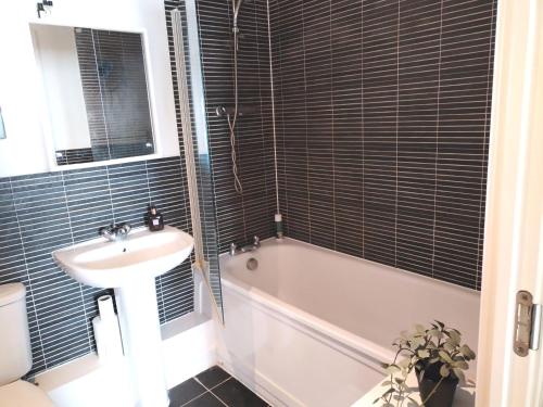 a bathroom with a sink and a tub and a toilet at Stylish flat in London, Canary Wharf in London