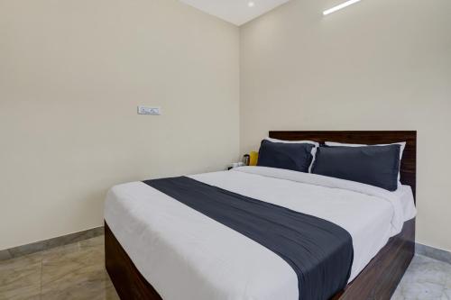 a bedroom with a large bed with blue pillows at Collection O S. M. Village Residency, Near DSR ELIXIR, Bidare Agrahara in Bangalore