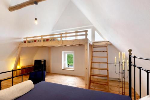 ein Schlafzimmer mit einem Hochbett und einer Leiter in der Unterkunft Ferienhaus Suzanne Mercimersea in Oberndorf