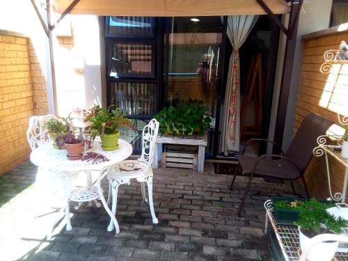 a patio with a table and chairs and plants at Charming apartment in Pretoria