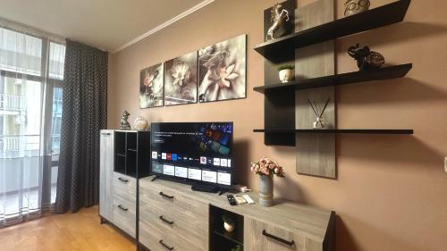 a living room with a flat screen tv and shelves at Bratanov Flower Street Apartment in Sunny Beach