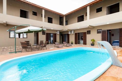 a swimming pool in front of a building at Cananeia Suítes in Cananéia