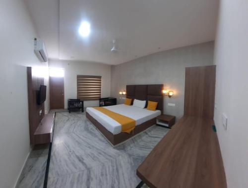 a hotel room with a bed and a television at OYO 820574 The Highclass Hotel in Bathinda