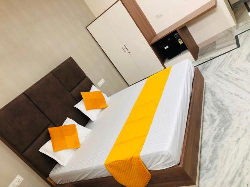 a bedroom with a bed with orange and yellow pillows at OYO 820574 The Highclass Hotel in Bathinda