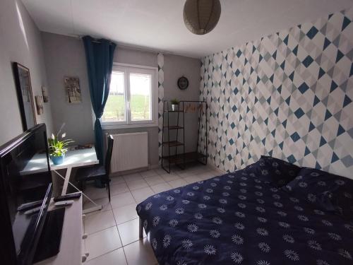 1 dormitorio con cama, escritorio y ventana en Chambre chez l'habitant avec Sdb et WC privatifs, en Marnay-sur-Seine
