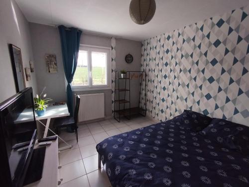 a bedroom with a bed and a desk and a window at Chambre chez l'habitant avec Sdb et WC privatifs in Marnay-sur-Seine