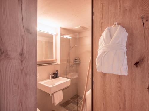 a bathroom with a sink and a white towel on a wall at B&B CCAA Ascona in Ascona