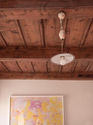 a chandelier hanging from a wooden ceiling with a painting at B&B CCAA Ascona in Ascona