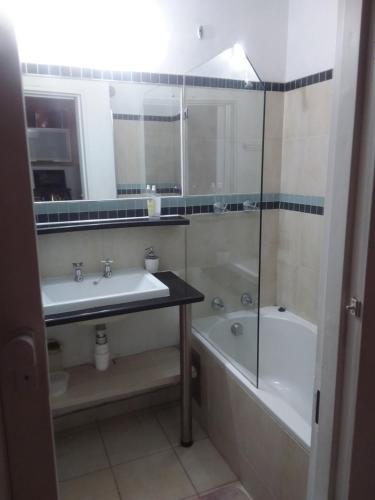 a bathroom with a sink and a tub and a toilet at Charming apartment in Pretoria