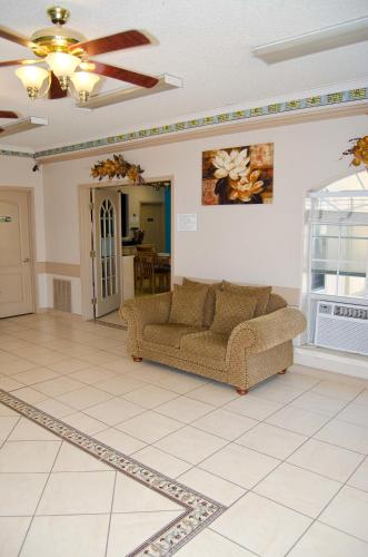 a living room with a couch on a tiled floor at Texas Inn and Suites City Center at University Dr. in Edinburg