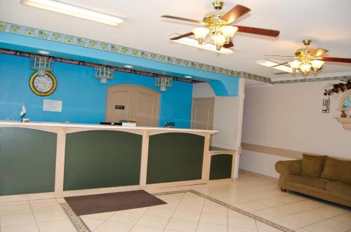 a living room with blue walls and a bar at Texas Inn and Suites City Center at University Dr. in Edinburg