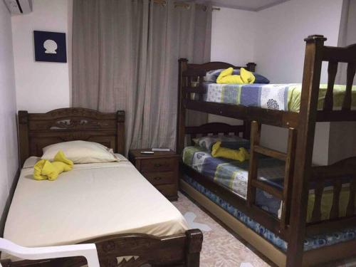 a bedroom with two bunk beds with yellow towels at DONDE MATHY'S #1 Apto Turistico Sarie Bay in San Andrés
