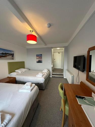 a hotel room with two beds and a television at The Imperial Hotel Exmouth in Exmouth