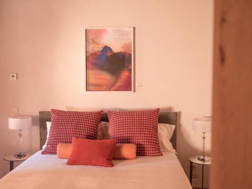 a bedroom with a bed with red and white pillows at B&B CCAA Ascona in Ascona