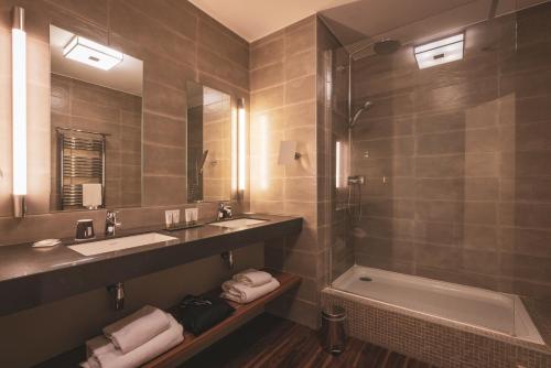 a bathroom with a sink and a shower and a tub at Le Forges Hotel in Forges-les-Eaux