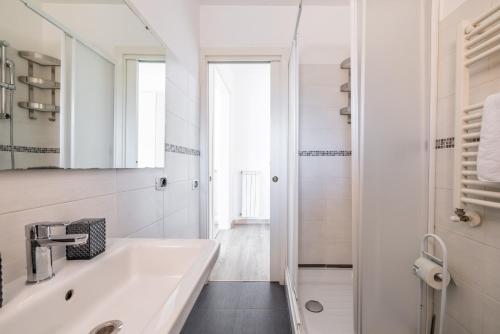 bagno bianco con lavandino e doccia di Maison Blu - in Trastevere a Roma