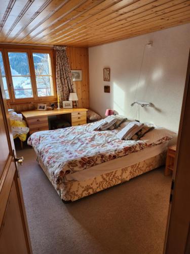 sypialnia z dużym łóżkiem i biurkiem w obiekcie Beautiful appartment in Les Diablerets w mieście Les Diablerets