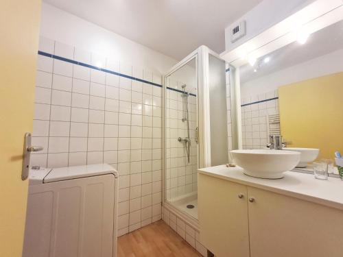 une salle de bain blanche avec un lavabo et une douche dans l'établissement Charmant appartement 4 pers,vue montagne avec parking privé et balcon, à Cauterets