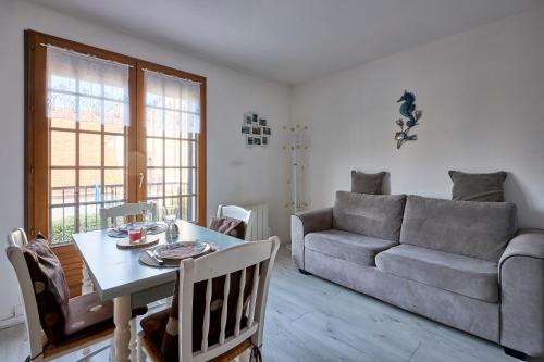 un salon avec un canapé et une table dans l'établissement Doudounette - Appartement à proximité de la plage, à Courseulles-sur-Mer
