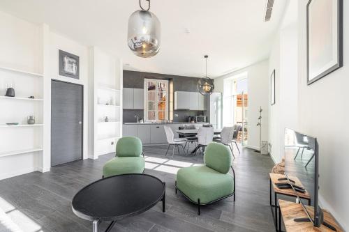 - un salon avec une table et des chaises vertes dans l'établissement Le Bréa, Élégant appartement, jolie vue mer, à Menton