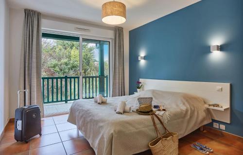 a bedroom with a bed and a large window at Résidence Odalys Domaine Iratzia in Saint-Jean-de-Luz