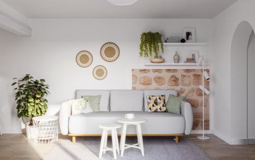 ein Wohnzimmer mit einem weißen Sofa und einem Tisch in der Unterkunft Robinsone House La Storia in Jelsa