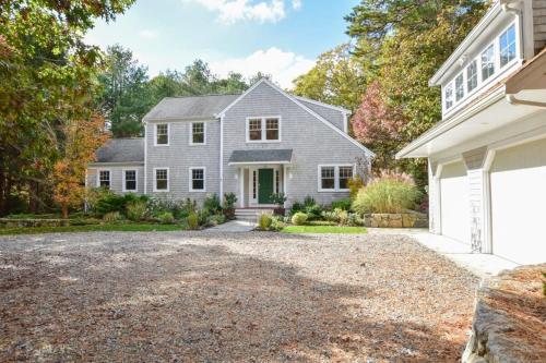 a large white house with a driveway at Perfectly private location w deeded beach access in Orleans