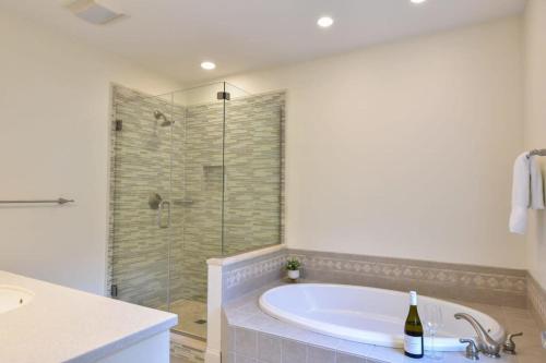 a bathroom with a tub and a glass shower at Perfectly private location w deeded beach access in Orleans