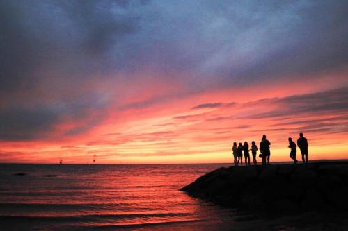 a group of people standing on the beach watching the sunset at Perfectly private location w deeded beach access in Orleans