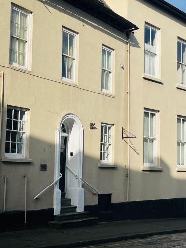 a white building with a white door and stairs at 6 Wye Valley Chambers, Ross-on-Wye in Ross on Wye