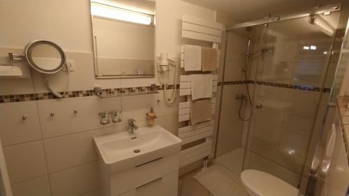 uma casa de banho branca com um lavatório e um chuveiro em Ferienhaus Giesela **** em Wernigerode