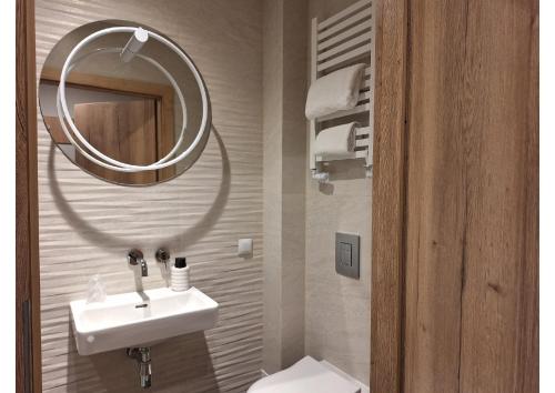 W łazience znajduje się umywalka, lustro i toaleta. w obiekcie Hotel Mazovia Airport Modlin w Nowym Dworze Mazowieckim