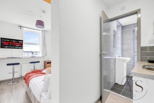 a bedroom with a bed and a sink and a window at Gorgeous Longton Studio 1b in Stoke on Trent