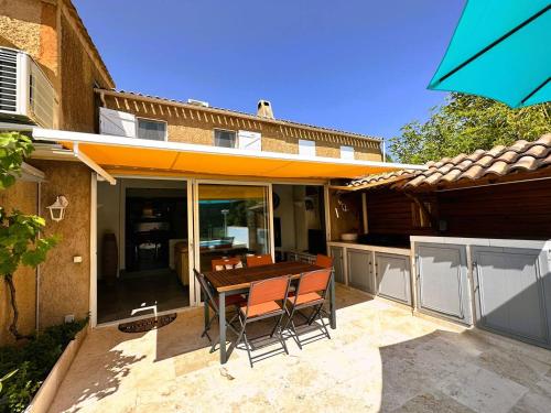 d'une terrasse avec une table en bois et 2 chaises. dans l'établissement Mazet de la Treille, climatisé avec piscine privée pour 4 pers Domaine privé, à La Londe-les-Maures