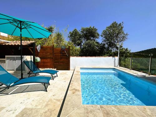 une piscine avec deux chaises et un parasol dans l'établissement Mazet de la Treille, climatisé avec piscine privée pour 4 pers Domaine privé, à La Londe-les-Maures