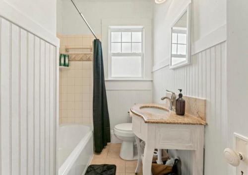 a bathroom with a sink and a toilet and a tub at Luxury Duplex 4 BR House In Jacksonville in Jacksonville