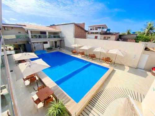 an overhead view of a swimming pool with umbrellas at Pousada Villa Goyá in São José da Coroa Grande