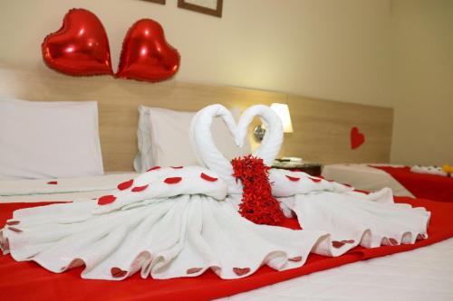 Dois cisnes vestidos de amor estão sentados numa cama em Hotel Coral Beach em Tamandaré