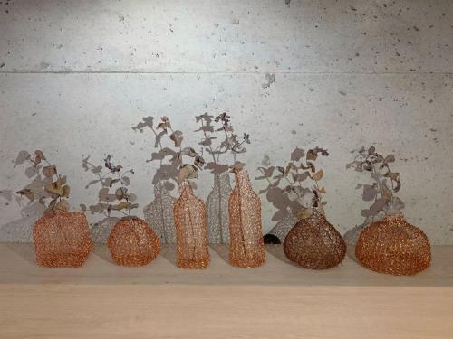 a row of glass vases sitting on a shelf at Penghu Somewhere Guesthouse 澎湖嶼光角落民宿 in Magong