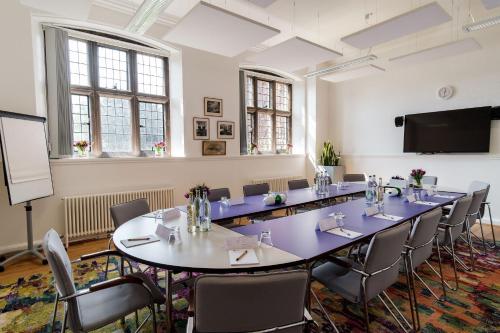 een vergaderruimte met een lange tafel en stoelen bij Westminster College in Cambridge