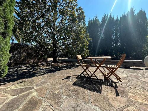 - une table de pique-nique et 2 chaises assises sur une terrasse dans l'établissement La Tranquille - rez de villa - jardin & plage, à Fréjus
