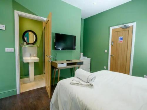 een groene kamer met een bed en een televisie bij Pass the Keys Traditional room Tavmar Apartments in Lincoln