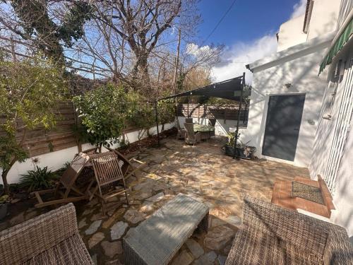 eine Terrasse mit 2 Stühlen, einem Tisch und einer Bank in der Unterkunft Casa Montseny - Con piscina - 6P in Empuriabrava